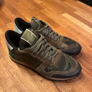 Valentino Rockrunner i camouflage - Säljer ett par snygga Valentino Rockrunner sneakers i camouflage. De är gröna och bruna med svarta detaljer. Skorna är i mocka och skinn.