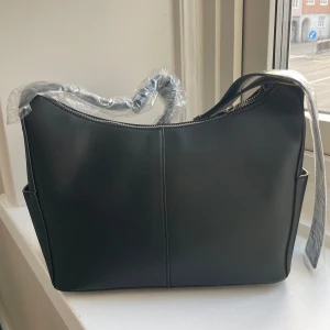 Svart axelväska från Zign - Snygg svart axelväska från Zign i fusk skinn med dragkedja upptill. 