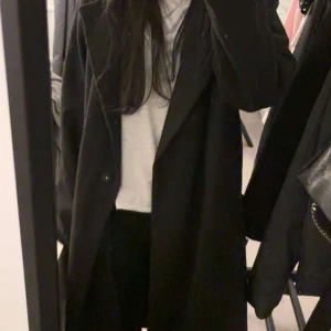 Svart kappa från Bik Bok - Snygg svart kappa från Bik Bok i storlek S. Den har en klassisk design med långa ärmar och knappar framtill. Perfekt för höst och vinter, och ger en stilren look till din outfit.💓