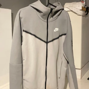 Kofta från Nike - Snygg grå Nike kofta med svart detalj på ärmarna. 