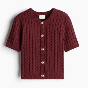 Vinröd kabelstickad kofta - Säljer en vinröd kabelstickad kofta med korta ärmar och guld knappar.  nästan helt oanvänd, förlåt för dåliga bilder kom privat för fler ☺️ 