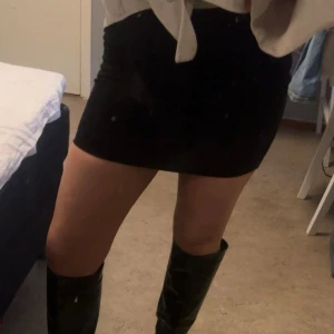 Svart kortkjol - Snygg svart kortkjol som passar perfekt till både vardag och fest. Kjolen har en tight passform och är enkel att matcha med olika toppar och accessoarer.