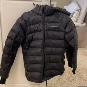 Svart dunjacka från Peak Performance - Svart peakjacka fint skick förutom ett litet slitage på armen (sista bilden). Är i strl 160 men passar xs/s. 