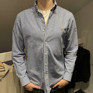 Blårutig skjorta från Ralph Lauren - Säljer en klassisk blårutig skjorta från Ralph Lauren i storlek S. Skjortan har en normal passform och är tillverkad i bomull. Perfekt för både vardag och fest! Skjortan är i jättebra skick! Nypris runt 1500 mitt pris endast 549kr