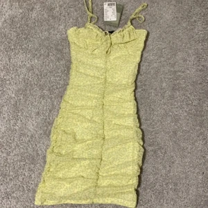 Svart blommig klänning med knyt - Säljer denna helt oanvända klänningen, köpte den för ett tag sen men den har inte kommit till användning💗andra bilden är samma modell men annan färg❤️