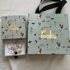  halsband med trollslända från Ioaku - Elegant silverfärgat halsband från Ioaku med en detaljrik trollsländeberlock. Perfekt för att ge en stilren touch till din outfit. Kommer i en vacker presentförpackning.