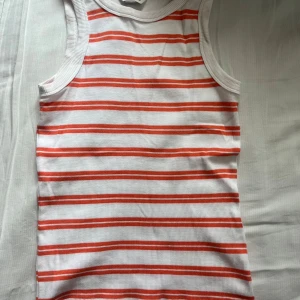 Vit och orange randig linnetopp - Säljer en vit och orange randig linnetopp med ribbat material. Perfekt för sommardagar. Aldrig använt🫶