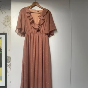 Rosa prickig maxiklänning från Boohoo - Säljer en superfin rosa klänning från Boohoo i storlek S. Den går ner till vristerna (jag är 1,68), har ett sött prickigt mönster och volangdetaljer vid halsen. Klänningen är kortärmad och har en bekväm passform med resår i midjan. Mycket fint fall och passar alla.  Perfekt året runt både till fest och vardag.
