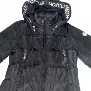 Svart dunjacka från Moncler - Säljer en snygg svart dunjacka från Moncler i mycket bra skick. Jackan har en huva med Moncler-logga och dragkedjor framtill. Perfekt för kalla vinterdagar. Den är både stilren och varm, med en klassisk design som passar till det mesta,Kom dm för fler frågor eller bilder(köparen står för frakt)💛💛💛