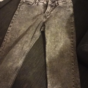 Grå jeans i bra skick - Säljer ett par grå jeans i bra skick. De har en klassisk femficksdesign och en snygg tvättad look. Perfekta för vardagsbruk och kan matchas med nästan vad som helst. Passformen är normal och de har en knapp- och dragkedjestängning.