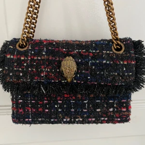 Väska från Kurt Geiger - En superfin väska i tweed från Kurt Geiger i den mindre modellen. Använd fåtal gånger och den är i jättebra skick. Kedjan i guldfärg går att ändra till både kort och lång. Modell: Kensington