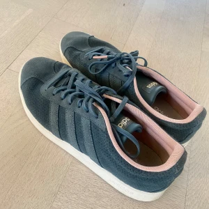 Adidas sneakers  - Snygga Adidas sneakers i en stilren blå färg med rosa detaljer. Skorna har klassisk snörning och en bekväm passform.