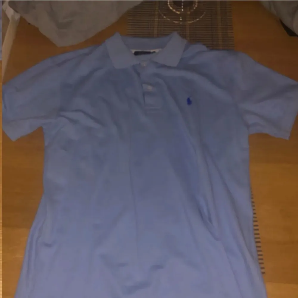 Säljer en klassisk ljusblå pikétröja från Ralph Lauren med korta ärmar och en liten broderad logotyp på bröstet. 7/10 skick. T-paidat.
