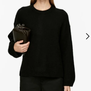 Arket Svart stickad tröja - Säljer en stilren svart stickad tröja med rund hals och långa ärmar. Perfekt för kyligare dagar och enkel att matcha med olika outfits.