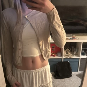 Beige kofta från 157 - Säljer en beige kofta från 157 i storlek S. Koftan har långa ärmar och knappar framtill. Perfekt för lager-på-lager och passar till många olika outfits. Skriv för mer information💕