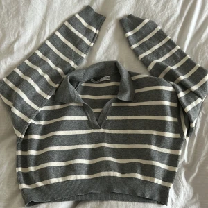 Randig croppad tröja - Säljer en randig tröja med krage. Tröjan är croppad och har långa ärmar, från bershka. Storlek M.