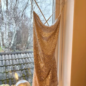 Glittrig guldklänning med paljetter - Säljer en fantastisk glittrig guldklänning med paljetter. perfekt för festliga tillfällen. Klänningen har en fin passform och är i mycket bra skick. Perfekt för nyår eller andra speciella tillfällen! ✨