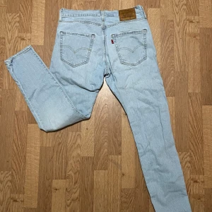 Ljusblå jeansbyxor från Levi's - Oanvända! Säljer ett par ljusblå Levi's jeans med klassisk femficksdesign och en bekväm passform. Byxorna har en dragkedja och knapp framtill samt den ikoniska Levi's-lappen på baksidan. Perfekta för en avslappnad stil.