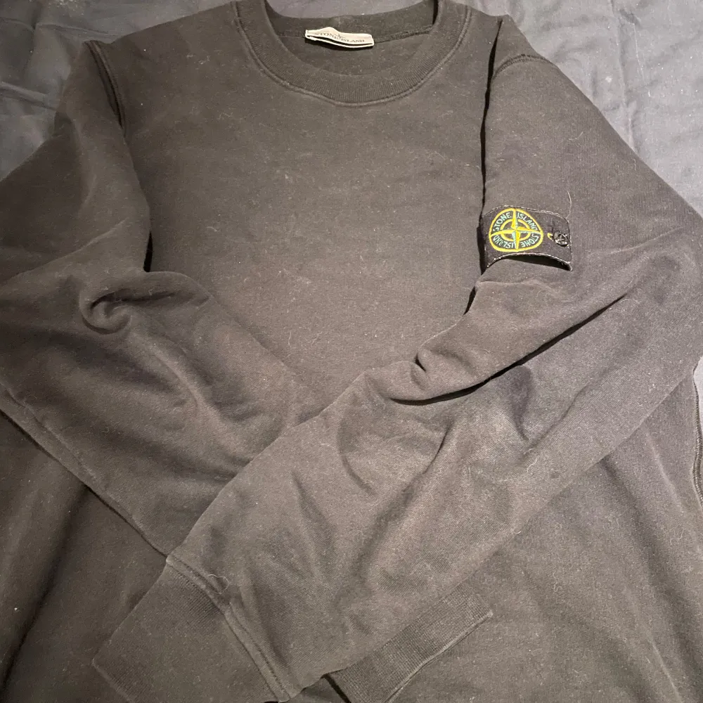 Säljer en svart sweatshirt från Stone Island i bra skick. Den har en klassisk rund hals och långa ärmar. På vänster ärm finns det ikoniska Stone Island-märket. Perfekt för höst och vinter, både stilren och bekväm.. Tröjor & Koftor.