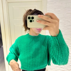 Grön stickad tröja från Zara - Säljer en superfin grön stickad tröja från Zara. Den är croppad och har en härlig, lös passform med långa ärmar. Perfekt för höst och vår när du vill vara både stilren och bekväm. Tröjan är i mycket bra skick och redo för nya äventyr! 💚 passar s/m storlek 