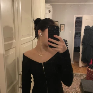 Svart offshoulder topp från Bershka - Säljer en snygg svart offshoulder topp från Bershka. Perfekt för en utekväll eller fest! Toppen är tight och har en dragkedja framtill för en cool look. Den är i mycket bra skick och passar perfekt till både jeans och kjol. 🖤