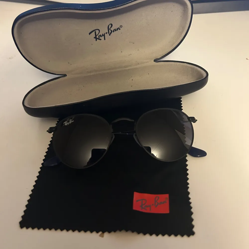 Säljer ett par snygga svarta Ray-Ban solglasögon i rund stil. De kommer med ett originalfodral och en putsduk. 😎. Accessoarer.