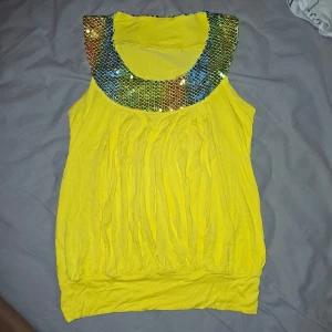 Festtopp - Supersnygg gul paljett topp med rund hals och mudd nertill. Riktigt snygg för en kväll på stan! Nyskick köpt utomlands är. Ca storlek XS-S 😊🩷