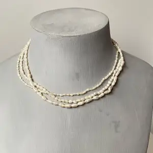 Säljer ett elegant halsband med flera rader av vita pärlor. Perfekt för både fest och vardag. Halsbandet har en fin guldfärgad låsdetalj som ger en extra touch av lyx. Passar till alla tillfällen där du vill känna dig extra speciell. 💫