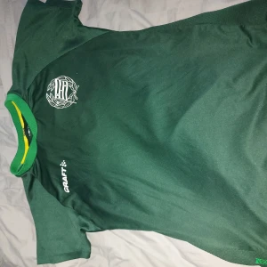 Bajen T-shirt limited edition - Säljer en limited edition bajen tshirt. Två likadan, en i storlek L och en i M. Tröjan har en gul och grön krage och texten 'BAJEN' på baksidan. Perfekt för fotbollsfans som vill visa sitt stöd eller vill träns i den. Båda kan köpas för 200kr