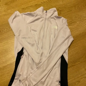 Ljuslila fleecejacka från The North Face - Säljer en supermysig ljuslila fleecejacka från The North Face. Perfekt för kyliga dagar med sin mjuka och varma känsla. Jackan har en dragkedja framtill och är långärmad. Den är i nyskick och redo för nya äventyr! 💜