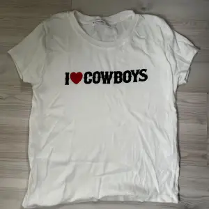 Säljer en vit t-shirt med 'I ❤️ Cowboys' tryck. T-shirten är kortärmad och i mjukt bomullsmaterial. Passar perfekt till jeans eller shorts. Skriv gärna om du är intresserad innan du köper 🫶