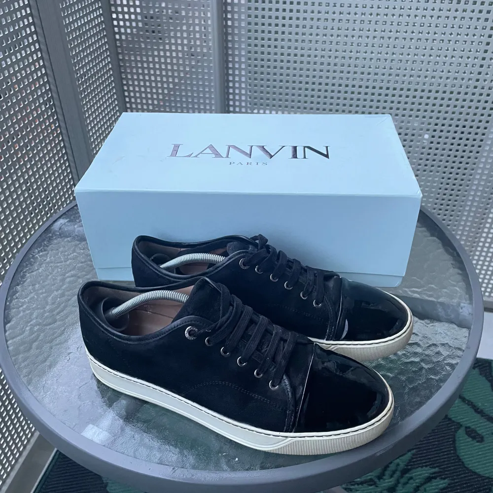 Säljer ett par snygga svarta sneakers från Lanvin i mycket bra skick. Skorna har en glansig finish på tån och snörning framtill. Använda fåtal gånger. De kommer med originalkartong, kvitto och extra snören🧾👞. Storleken uk 9 som motsvarar storlek 43/44 passar även dig med 42 om man lägger ner sula. Perfekta för både vardag och speciella tillfällen. (Lite blöta pågrund av rengöring) frågor eller annat skriv i dm. . Skor.