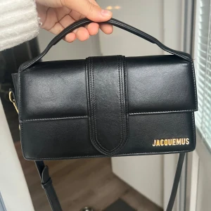 Large Bambino Jacquemus - Säljer min superfina Bambino från Jacquemus i storlek large. Perfekt för både vardag och fest!🖤Köpt för ungefär 3 år sedan, skicket är fint men har dock lite repor, inget märkvärdigt! Nypriset för denna är ca 9000 kr. Pris kan diskuteras!