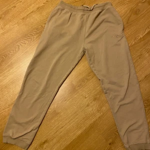 Beige mjukisbyxor från Vinson - Säljer ett par bekväma beige mjukisbyxor från Vinson. De har en elastisk midja med snörning för perfekt passform. Perfekta för en avslappnad dag hemma eller en promenad i parken. Byxorna är i bra skick och redo för nya äventyr! Pris kan diskuteras.