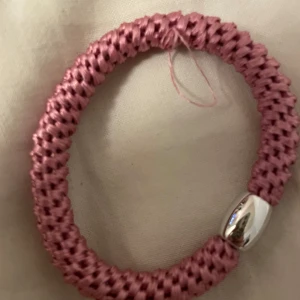 Rosa flätat armband med silverdetalj - Snyggt rosa flätat armband med en elegant silverfärgad detalj. Perfekt för att ge en färgklick till din outfit. Armbandet har en enkel och stilren design som passar både till vardags och fest. Ett måste för smyckesälskare! 💖