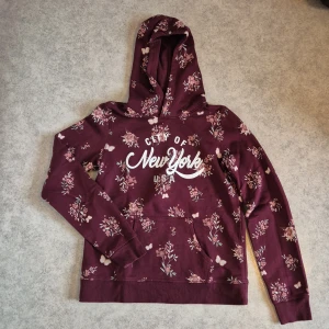 Mysig hoodie - Mysig vinröd hoodie med blommor och fjärilar! Använd men i bra skick!