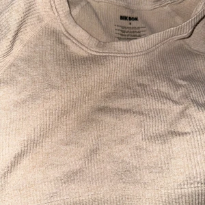 Beige ribbad croppad tröja från Bik Bok - Säljer en superfin beige ribbad tröja från Bik Bok. Den är croppad och har långa ärmar, perfekt för en chill dag eller att matcha med höga jeans. Materialet är mjukt och stretchigt, vilket gör den bekväm att bära hela dagen. Passar perfekt till både vår och höst!