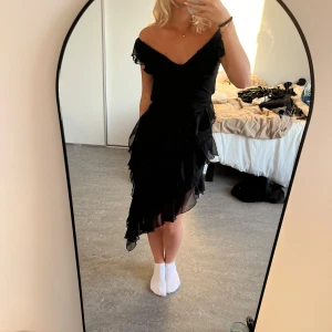 Klänning - Jättevacker svart klänning med volanger. Använde på mösspåtagningen men har inte kommit till användning sen dess. Skadad på ett ställe men går att fixa:)