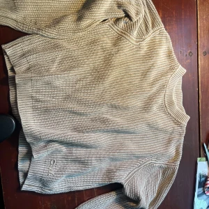 Beige stickad tröja från Calvin Klein - Säljer en snygg och stilren beige stickad tröja . Perfekt för höst och vinter med sin varma och mjuka känsla. Tröjan har långa ärmar och en klassisk rund halsringning. Passar både till vardags och lite finare tillfällen.