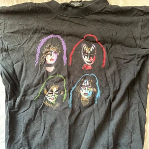 KISS T-Shirt - Säljer min gamla KISS tröja då den har blivit för liten för mig, och har därmed inte använts på flera år. Jag har använt den mycket, samt att det hänger en liten lös tråd vid ena ärmen, men tröjan är i gott skick i övrigt.