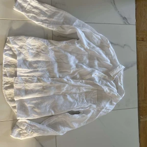 Vit linneskjorta - Säljer en fräsch vit skjorta i linne. Perfekt för sommardagar med sin lätta och luftiga känsla. Skjortan har långa ärmar och en klassisk krage. Den är i nyskick och redo för nya äventyr!