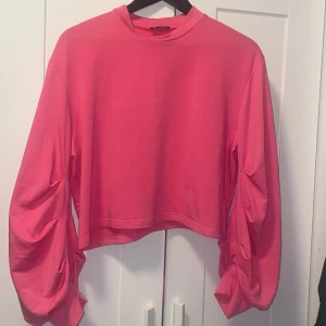 Rosa croppad tröja från Nobody's Child - Säljer en superfin rosa croppad tröja från Nobody's Child. Den har långa ärmar med en cool rynkad detalj som ger den en unik look. Perfekt för både vardag och fest! 💖