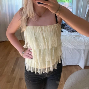 Volang topp - Volang blus/topp. Ljusgul med mesh volanger och prick detaljer. Den är av klippt nere på blusen men det syns knappt pga det är tyg över ❤️❤️(min kompis på bilden)
