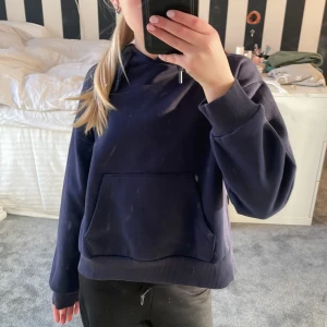 Mörkblå hoodie från Gina Tricot - Säljer en stilren mörkblå hoodie från Gina Tricot. Den har en klassisk design med en stor huva och en praktisk magficka. Perfekt för en avslappnad look. Använt några gånger men ser inte använd ut❣️