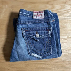 Flare True Religion jeans - säljer mina as snygga jeans från true religion i flare modell, d är även köpta här på plick💕tyvärr finns det två små hål på baksidan av byxan (som ni kan se på bilden) men de syns knappast! det finns även lite slitningar längst ner på byxorna, kom privat för bild! priset är diskuterbart, kom även gärna privat för mått/frågor!💘