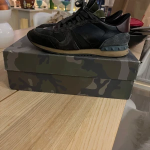 Valentino rockrunners - Snygga Valentino Garavani rockrunners i svart och grått med kamouflagedetaljer. Skick 7/10 använda men inga skavanker. Storlek 41-42. Tveka inte på att höra av dig.