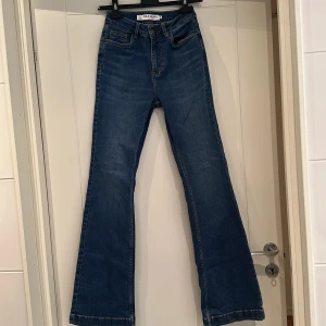 Blå jeans från Pulz Jeans - Snygga blå jeans från Pulz Jeans med bootcut-stil. De har en klassisk femficksdesign och är tillverkade i denim. Perfekta för en avslappnad look.