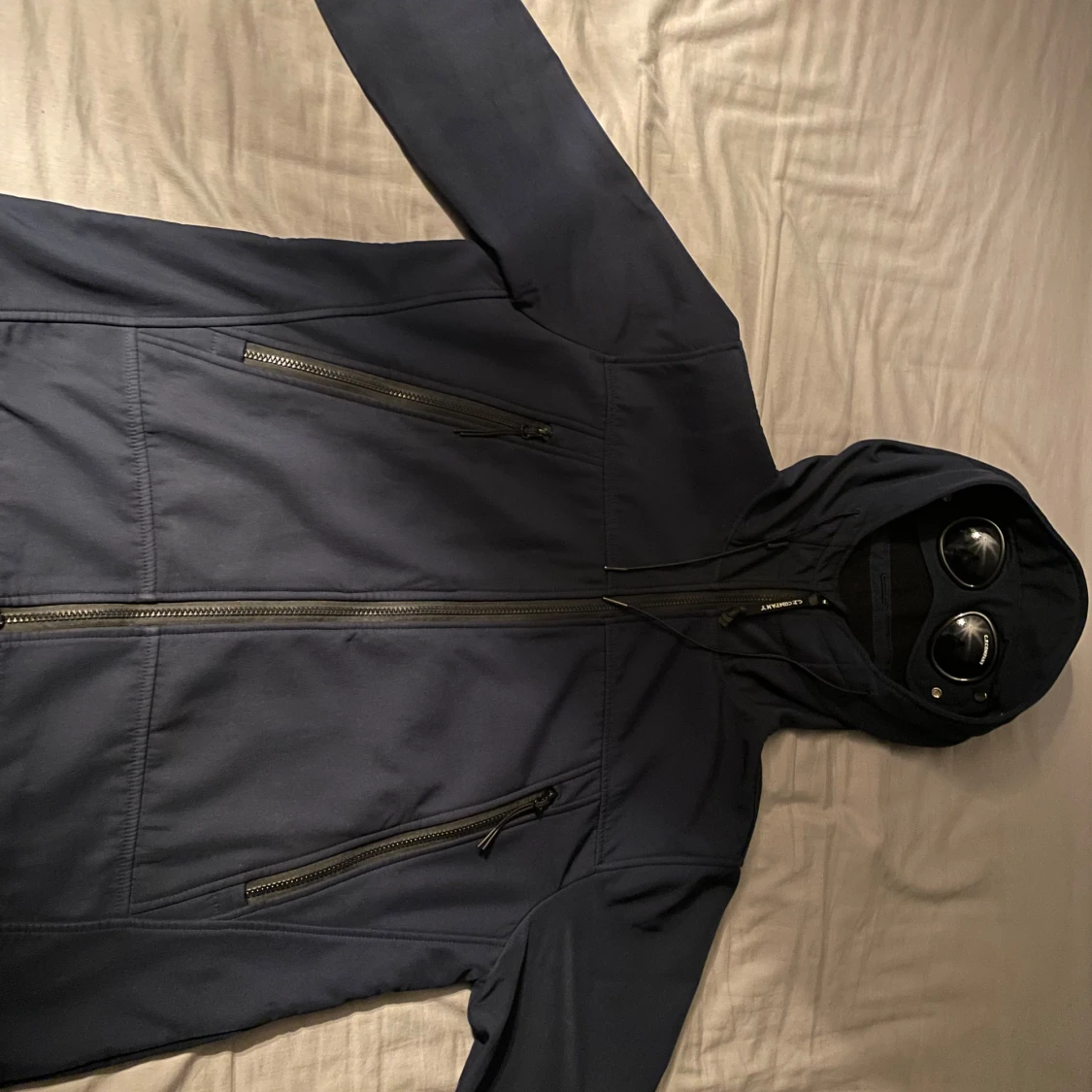 Svart jacka med huva och glasögon