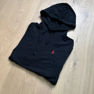 Svart hoodie från Ralph Lauren - Tja! Säljer en skön Ralph Lauren Hoodie i T-shirt material. Svart storlek S riktigt skön passform. Lite skrynklig kanske men annars som ny. Hör av dig vid frågor eller liknande✌️