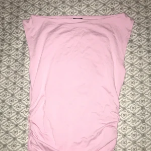 Rosa tubtopp från Gina Tricot - Säljer en mjuk rosa tubtopp från Gina Tricot i storlek XS. Toppen är i ett stretchigt material och har en enkel design som passar perfekt för varma dagar. Den är märkt med 'soft touch' för extra komfort.